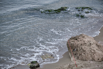 Sea waves during overcast weather. Turquoise sea waters clashing on the stones existion on the...