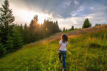 Girl enjoy pure nature. Walk over the field to meet sunset