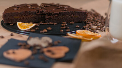 slices of chocolate brownie cake with glass of milk and coffee beanas on wooden table
