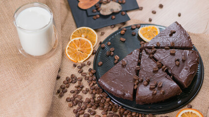 slices of chocolate brownie cake with glass of milk and coffee beanas on wooden table