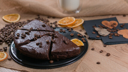 slices of chocolate brownie cake with glass of milk and coffee beanas on wooden table