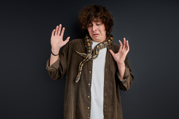 man cannot move when a snake wraps around his neck and shoulders, stand in shock, crying