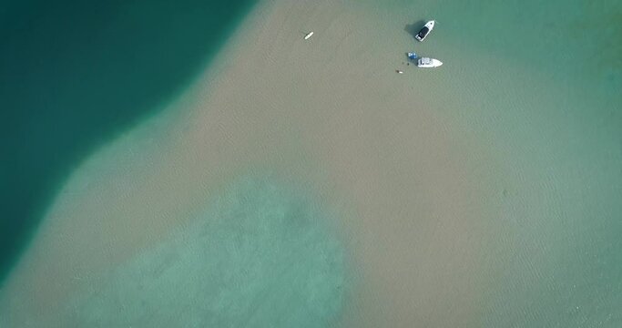 Drone aerial view of boats anchored on sandbar in the crystal clear waters of Torch Lake, Michigan.  