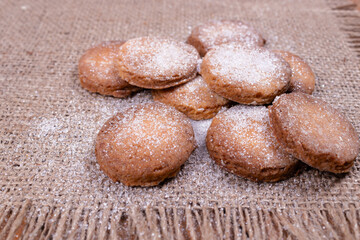 Fototapeta na wymiar side view of cookies in a pile with white sprinkles lying on a gray rug with fringes