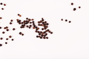 small balls of black and brown color are scattered on a white surface