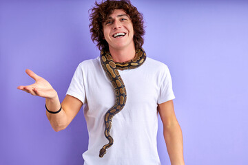guy stand with snake on neck, he is brave, has no phobia, speaking and smiling . isolated purple...