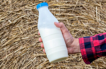 man drinks fresh bio milk on the field in the background, hay, grass, farm