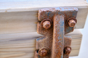 Wooden bench and its metal side exposed to corrosion and remainings of corrosion. Corrosion nut and stud for assembling of wooden side of back to metal frame.