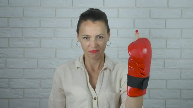 Angry woman boxer. Feminist in boxing gloves shows the middle finger.