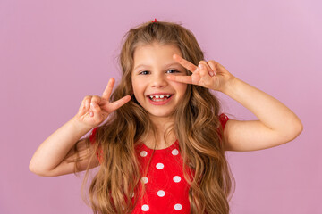 A little girl on a purple background shows her fingers.