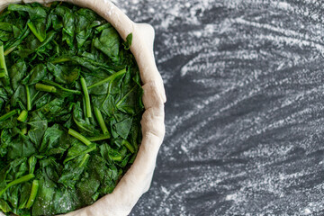 raw spinach pie preparation Standing wooden table background