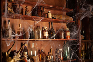 Fototapeta na wymiar Halloween background Shelves with alchemy tools Skull spiderweb bottle with poison candles