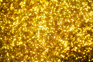 Gold defocused glitter.  Bokeh light of gold glitters background. 