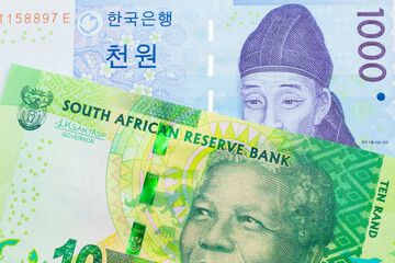A macro image of a shiny, green 10 rand bill from South Africa paired up with a blue and white one thousand won bill from Korea.  Shot close up in macro.