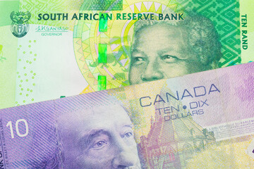 A macro image of a shiny, green 10 rand bill from South Africa paired up with a purple ten dollar bill from Canada.  Shot close up in macro.