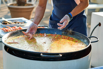 Italian restaurant chef holding shrimp in his hands