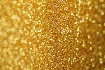Gold defocused glitter.  Bokeh light of gold glitters background. 