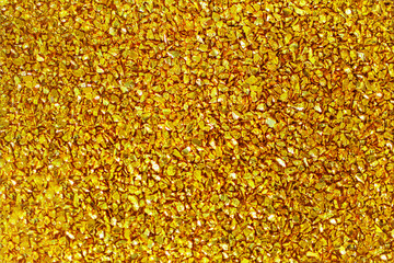 Gold defocused glitter.  Bokeh light of gold glitters background. 