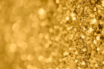 Gold defocused glitter.  Bokeh light of gold glitters background. 