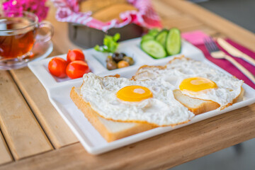 Fried eggs sunny side up on bread with side dishes. Breakfast of sunny side up eggs. Weekend breakfast concept with sunny side up eggs