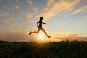 Side view of a woman running at sunset, Thailand