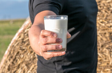 man offering a glass of fresh milk to the field