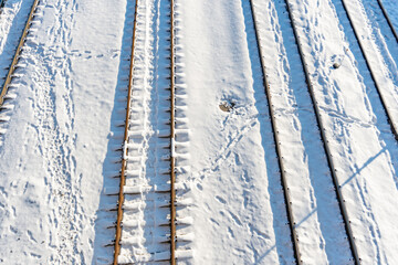 Train station, trains tracks, rails in the snow at sunset