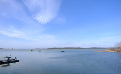 Magnificent sky and cloud shape on the lake of Uluabat town in Bursa. Boats on the lake part of town observing from photo.