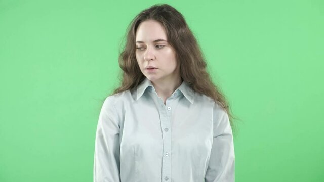 A young girl with signs of a mental disorder experiences a panic attack on an isolated green background. Autophobia. A panic attack.