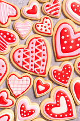 assortment of homemade heart shaped valentines sugar cookies with red, pink, and white icing designs