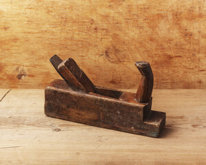 Old wooden hand plane for woodworking on table.