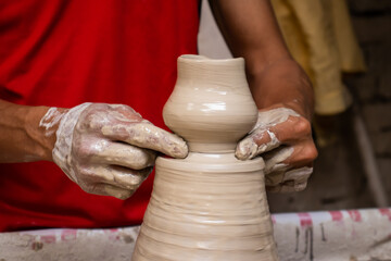 Man making ceramic articles on the pottery wheel in a traditional factory in the city of Ráquira located in the department of Cundinamarca in Colombia