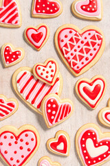 assortment of homemade heart shaped valentines sugar cookies with red, pink, and white icing designs