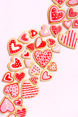 assortment of homemade heart shaped valentines sugar cookies with red, pink, and white icing designs