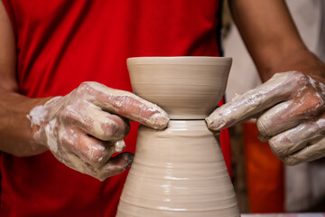 Man making ceramic articles on the pottery wheel in a traditional factory in the city of Ráquira located in the department of Cundinamarca in Colombia