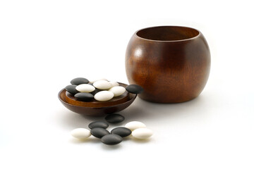 baduk stones with wooden bowl on white