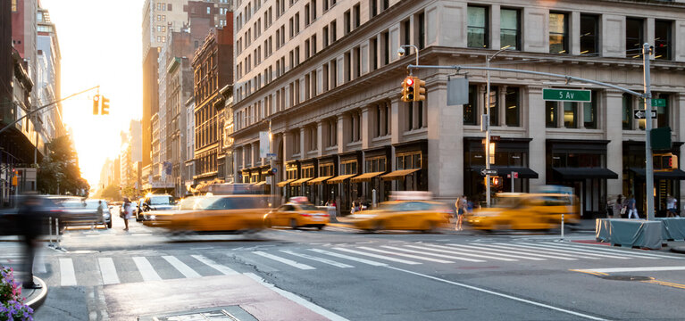 Yellow taxis driving through the busy intersection of 5th Avenue and 23rd Street in Manhattan, New York City