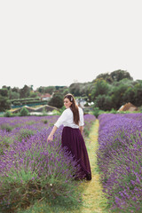 The young happy woman is walking in the Lavender field