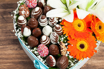 Beautiful Valentine's Gift; a heart-shaped box filled with chocolate-covered strawberries accompanied by flowers.