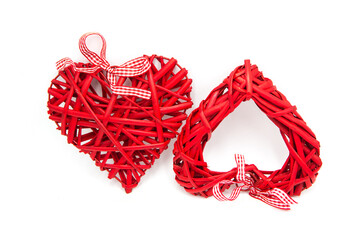 Pair of decorative red wicker hearts with ribbons isolated on white background. The concept of true and mutual love.