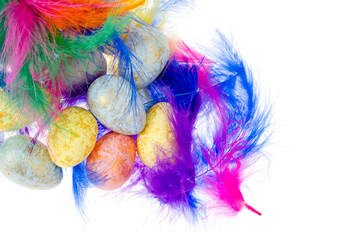 Decorative colored eggs and feathers on white background
