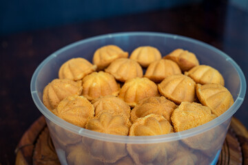 Kuih Bahulu, baulu or bolu in a container. Sponge cake baked in special aluminium moulds is the Asian tradition food in popular Malaysia and Indonesia.