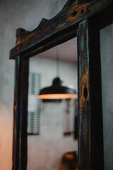 reflection in the mirror of the luminaire with warm light. Mirror with antique wooden edge. architecture template