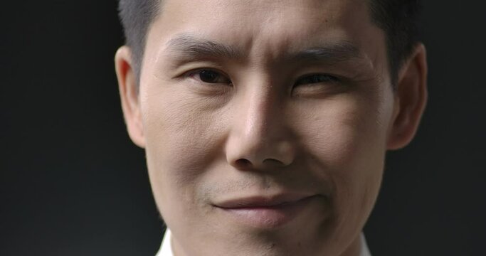Portrait and close up shot of young handsome asian businessman looking to camera with attractive smile. People and business concept. Slow Motion.