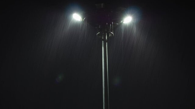 spotlight at night in heavy rain in light beams. beautiful water drop through the light. the electric streetlight in the park. timelapse footage of night scene in rainfall rainy season. nature b roll