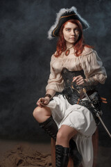 Woman is wearing black corset bustier, tricorn hat, gun belt and armed with pistol and sword