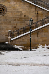 Fototapeta na wymiar lighting and snowy stairs on the old Charles Bridge in the center of Prague during the day in winter 2021