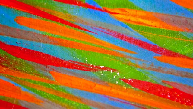 Many different colored lines painted bright paint on canvas close-up. Green, orange, red, blue colors. Brush strokes on canva. Cracks, scratches. Abstract grunge multicolored creativity art background