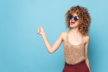 Lady curly hair More fun red lips gesture with hands studio blue background 