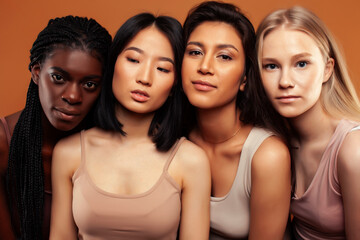 Obraz premium young pretty asian, caucasian, afro woman posing cheerful together on brown background, lifestyle diverse nationality people concept